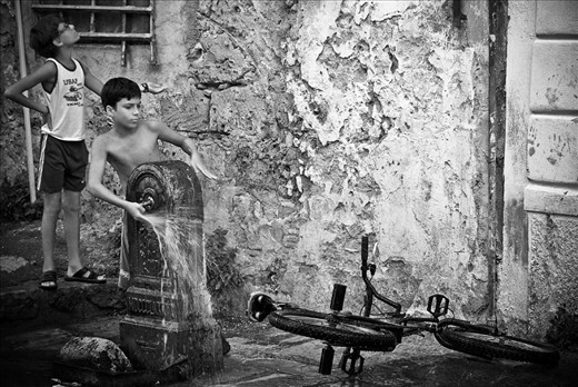 Two kids washing a bicycle in 