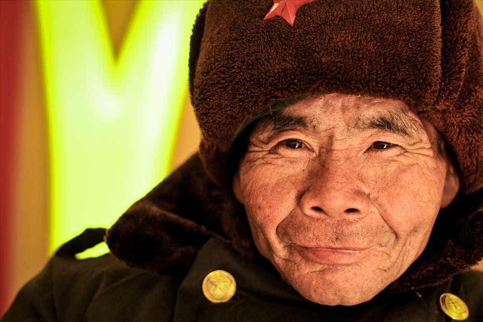 A gracious man dressed in an old army coat and hat at a McDonald's in a tourist area of the city of Wuhan, capital of central China's Hubei Province. Each day he spends his time offering to take people's trays away for a little bit of change.