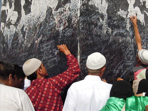 People writing their names on the tower where Adam & Eve met.