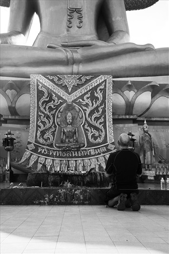 Praying in front of a giant Buddah.