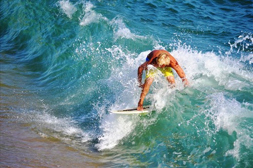 A little bit further, a man aims to find his own equilibria amongst ocean waves