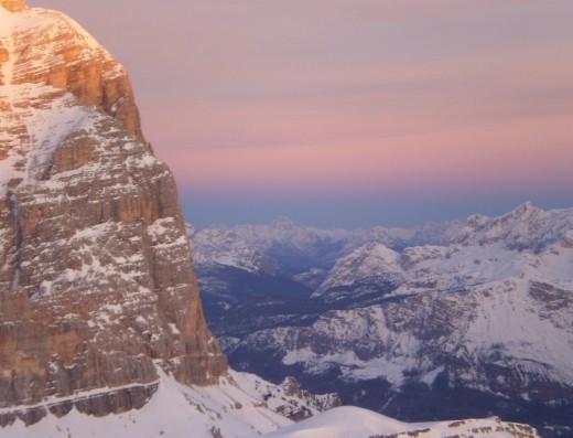Dusk settles, providing a warm backdrop for the snow capped peaks at Rifugio Lagazuoi.