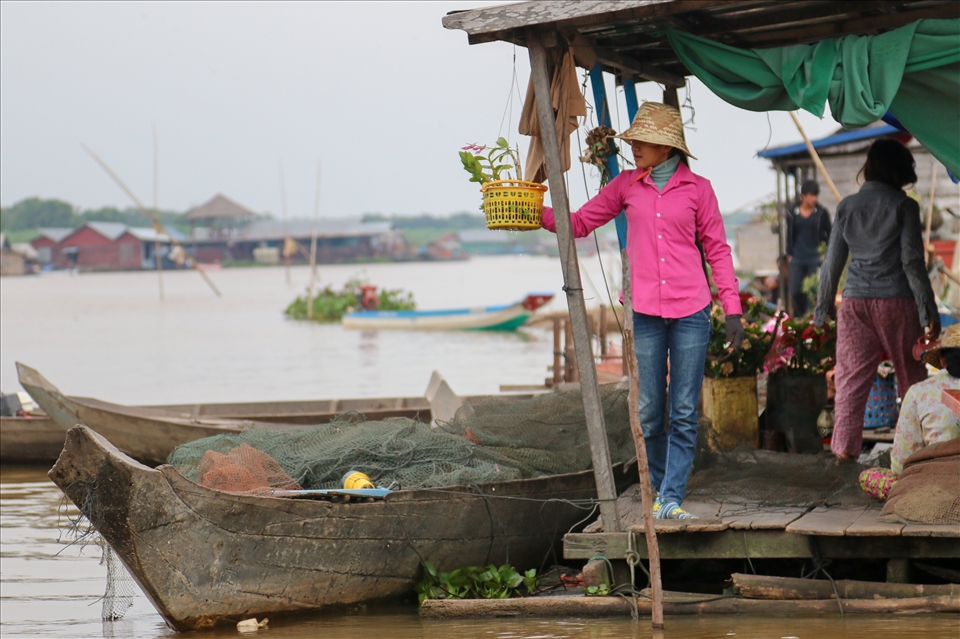 A fisher girl taking a break by the boats in Tonle Sap