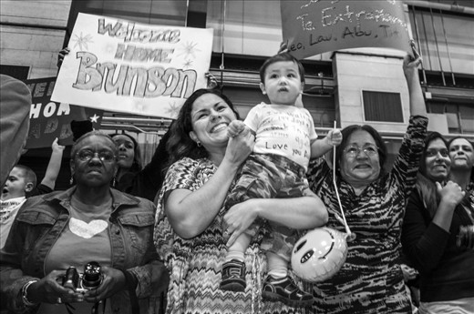 Laura Jimenez, Jesus's wife, cried with joy as she holds her one-year-old son, Leonardo. She was waiting a year for this moment when her husband would return home safely from Afghanistan. She is surrounded by other families welcoming their soldiers home with banners and open arms.