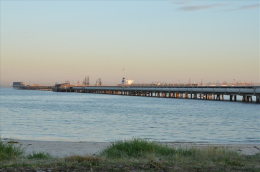 The majesty of the bay meets the protruding arm of the refinery. All that is visible is the large tankers queing to remove their gold, and the signs on the pylon, telling me I have to stand well back or risk prosecution.