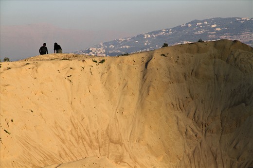 A hill of sand gravel suspended in the sunset is entitled to become as majestic as the view it's intended to host. For the time being, foreign construction workers are the ones privileged to roam her liberating peaks.