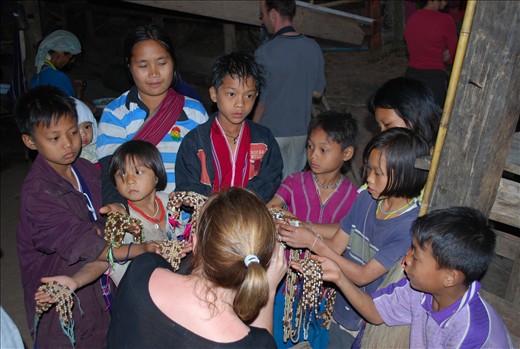 A new group of tourists  are greeted by the village children hoping to sell their jewellery. 