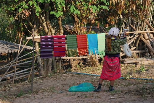 A woman wakes early to display her scarfs for the daily sale.