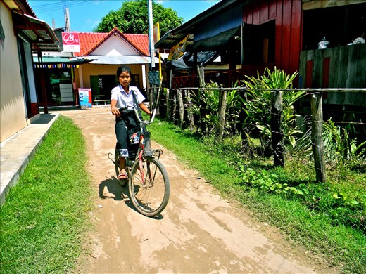 A local girl biking home stops for a photo.