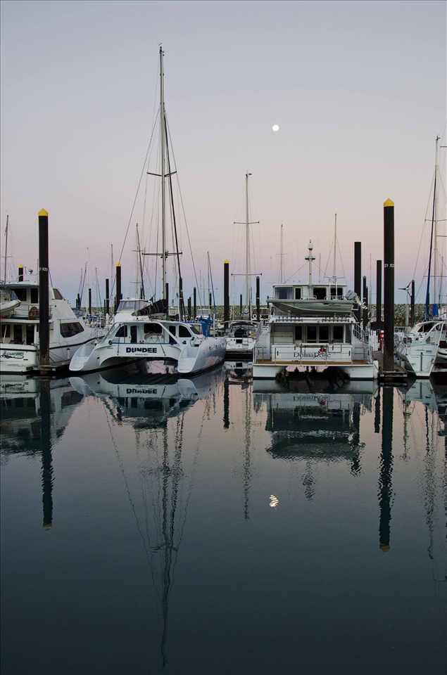Full moon rising over the marina and people settle in for the night.