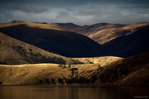 Clouds from a mid-day storm pass over the rolling hills next to Laguna De Paca. The lake, a short drive away from Huancayo in the central Andes, has become a fixture for local day trips and fishermen. Houseboat restaurants serve trout on the shore, though since the economic recession less tourists have come visiting.

Walking there from nearby Jauja, I met some local residents with whom I sat down to enjoy the sunset. These fleeting encounters will stay with me all my life, even if I don't remember their names. Thanks to my camera, however, I will never forget their faces, or the beautiful land in which they lived. I consider that a great privilege.  