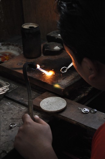 Hard at work.  A Balinese jewellery maker turning a silver ring. This factory is one of Bali's largest manufacturing and exporter of jewellery.  Work safety conditions would be illegal here in Australia but not the case in Bali