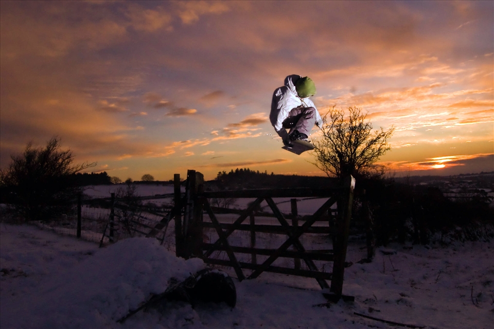 A rare chance and making use of little snow locals play on their snowboards.