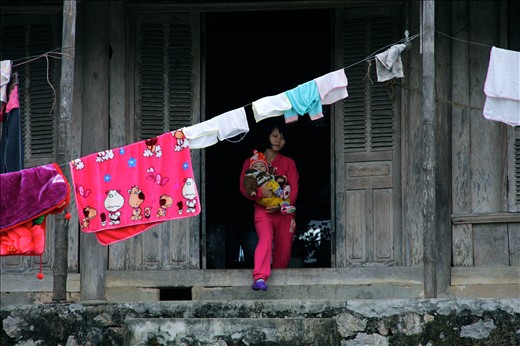 A woman and baby emerge from their home in the 1000-person village.