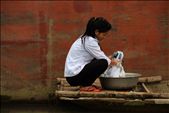 A young woman washes clothes beside her boat in the floating village.: by lucyellensteadman, Views[539]