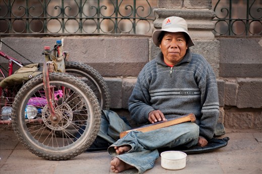 With no use of his legs, this man has a modified hand-pedaled trike he uses to transport himself around.  He plays music on a hand-made walaycho, a Peruvian stringed instrument, to make a living.  San Pedro Marketplace, Cusco, Peru.