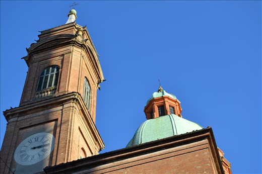 Sunset and play of lights on roofs of Bologna's churches..