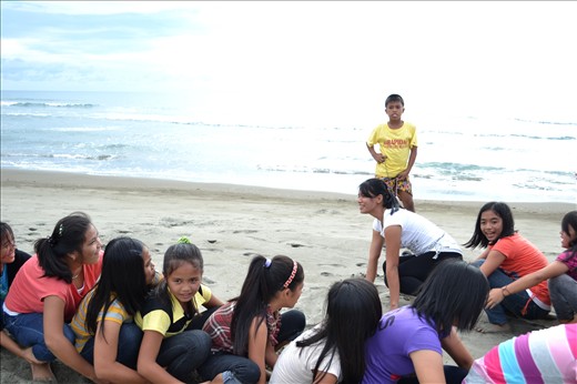 OBSERVING-While these young ladies are having fun on their caterpillar game, this boy is seriously observing what they are doing. 