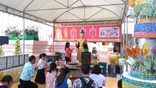 Phra Pathom Chedi School - Worshippers applying gold leaf to statue