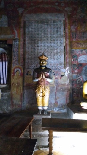 King Kirti Sri Rajasinh deferentially facing the Buddha statue
