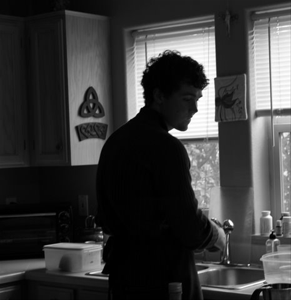 My brother washing dishes after he's baked bread.