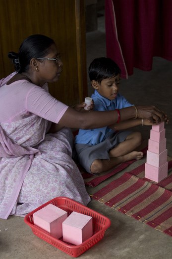 The society also has a school that now provides an education to over 300 children living nearby. Here, Rupa, one of the veteran teachers shows her student how to count using wooden blocks. 