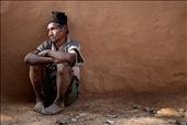 A subsistence farmer, he lives from hand to mouth.  Separated from the group, this weathered Chepang man leans against a mud house in sombre reflection. : by magdalena_smieszek, Views[700]