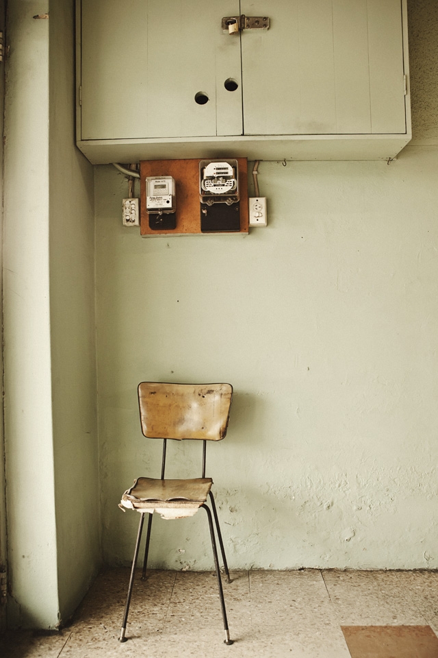 SOLITUDE A worn and expectant chair; the start of a new day. The Laundromat is a silent meeting place for people of all walks of life. A common ground, where mutual respect is established and common societal boundaries are dissolved. This chair sees all who come in and out, and by the look of it, becomes intimate with many. The chair is weary, but also refelcts a peaceful calm. A perfect metaphor for the laundromat itself.