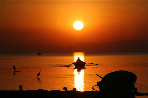 FISHERMAN ROW ON BOAT AT SUNRISE IN CHAPALA LAKE