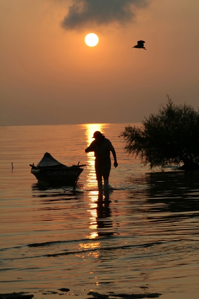 FISHERMAN GETS OUT OF LAKE