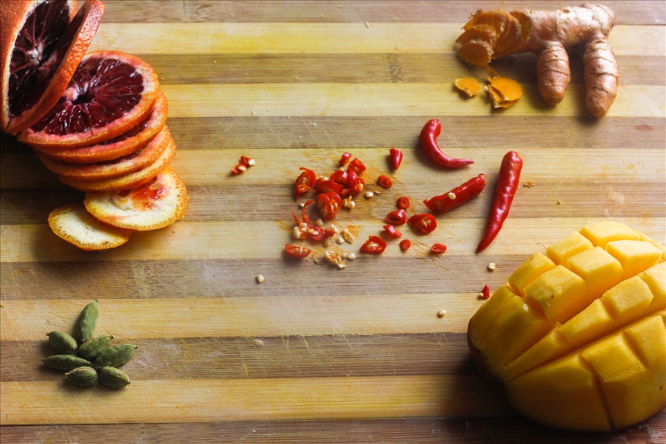 Processing raw ingredients to go into blender:
Blood red orance(upper left)
Mango(lower right)
Turmeric root(upper right)
Cardamon pods(lower left)
Red Chili peppers(center)