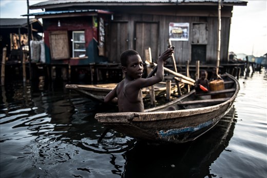 A young kid dirves a canoe in Makoko Slums.