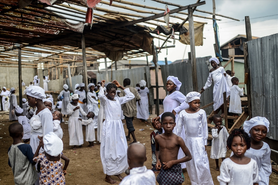 Christians wait for a religious ceremony at the Church of God in the floating sl