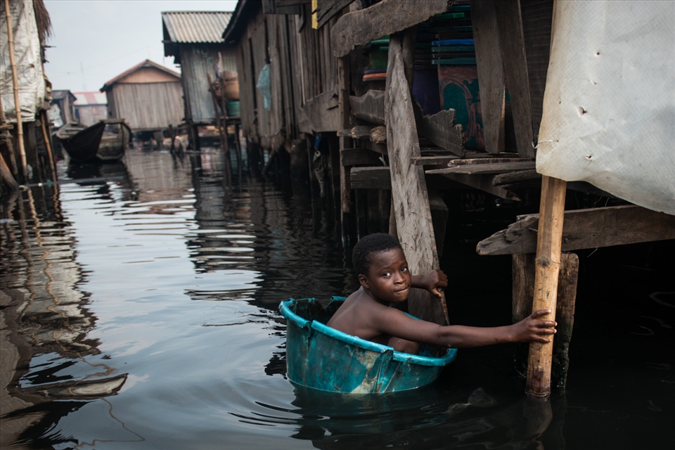 A young boy swims in through dirty oily water of Nigeria's Makoko slum. 30 April