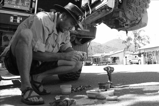 Pat a 'la Mac Guyver is fixing a hole in a fuel tank