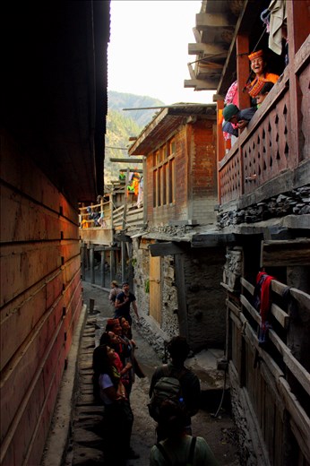 Kalash children on the balcony of their home in Bumburait Valley share a laugh with Pakistani tourists below.
<p>
Today, tourism forms one of the mainstays of Kalash economy, along with the traditional occupations of goat-herding and farming. Every year during the three festival seasons – spring, autumn and winter – tourists from the Pakistani lowlands, as well as a steady number of brave foreigners, throng to the Kalash Valleys to witness the rituals and way of life of these people, the last truly indigenous people of Pakistan. While the Kalash are generally very friendly and hospitable, not everybody is happy about the seasonal invasions of their privacy. 