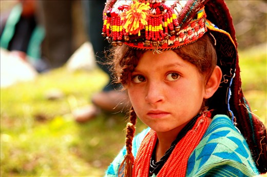 Meet Zarmina, 10, lost in innocent thoughts as her village gears for the <i>Joshi</i> spring festival, held in late May each year to mark the passing of the cold season and the planting of new crops. 
<p>
Zarmina is a <i>Kalasha</i>, progeny of an ancient Indo-Iranian tribe that has fascinated travelers and mystified anthropologists for centuries. The polytheistic Kalash once thrived in the fertile valleys of the Hindu Kush mountains in present-day Pakistan; today, with their distinctive religion and cultural practices under constant threat from Muslim proselytism, the Kalash are among the most endangered peoples in the world.