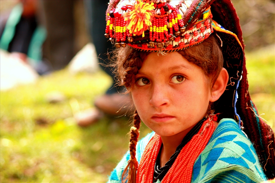 Meet Zarmina, 10, lost in innocent thoughts as her village gears for the <i>Joshi</i> spring festival, held in late May each year to mark the passing of the cold season and the planting of new crops. 
<p>
Zarmina is a <i>Kalasha</i>, progeny of an ancient Indo-Iranian tribe that has fascinated travelers and mystified anthropologists for centuries. The polytheistic Kalash once thrived in the fertile valleys of the Hindu Kush mountains in present-day Pakistan; today, with their distinctive religion and cultural practices under constant threat from Muslim proselytism, the Kalash are among the most endangered peoples in the world.