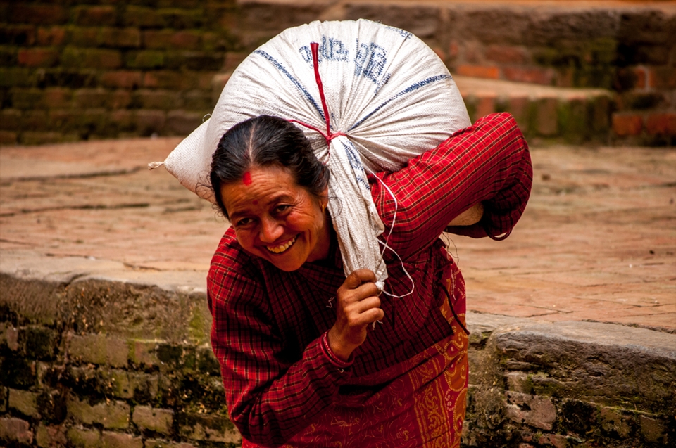 Bhaktapur, A lady carrying loads to pottery square. Despite seeing millions of the tourists every year, people are really humble and content in their hard working daily life. Her smile irrespective of the weight she is carrying has the essence of the Nepal. It never changes the basic nature of their life no matter whoever visits them.