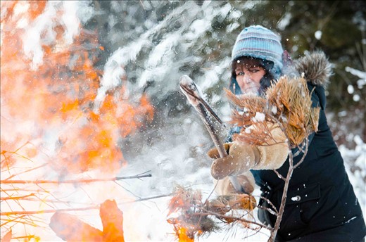 After a large windstorm blew through Fort Frances Ontario, a 100-year-old tree was ripped from its roots only a few feet from Paul and Lisa Cousineau’s cabin. Lisa uses a pickaxe to add the remains to the fire.