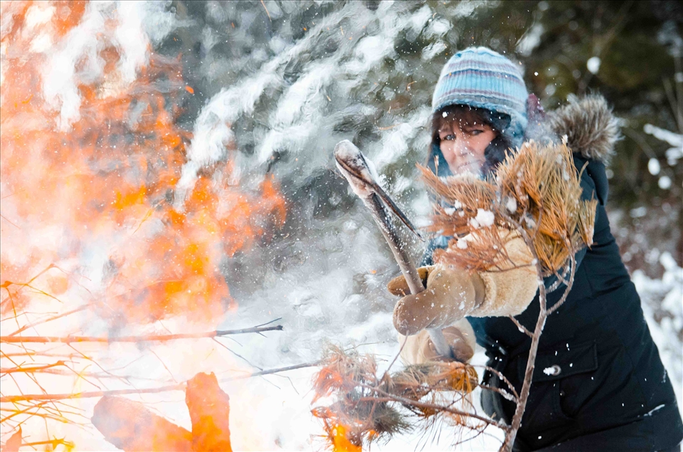 After a large windstorm blew through Fort Frances Ontario, a 100-year-old tree was ripped from its roots only a few feet from Paul and Lisa Cousineau’s cabin. Lisa uses a pickaxe to add the remains to the fire.
