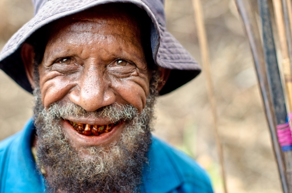 Grandfather Negundi on his way home from an unsuccessful day hunting with his bow and arrow. Although he doesn’t know his precise age, he thinks he is roughly 70 years old. His teeth are stained red by years of chewing a mixture of betel nut and crushed coral, a highly alkaline paste that causes the teeth to rapidly decay. For a man of his age in the Karunga Valley, Mr Negundi has a fine set of teeth. 