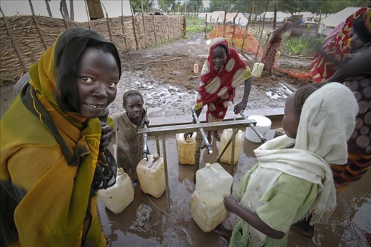 Women gather at a borehole in the camp to gather water for cooking and laundry. 