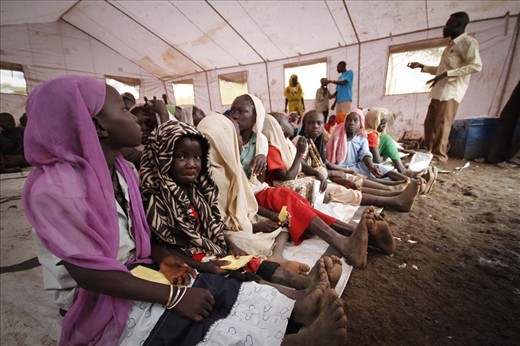 Young girls and boys gather in the camp's makeshift school to learn English.