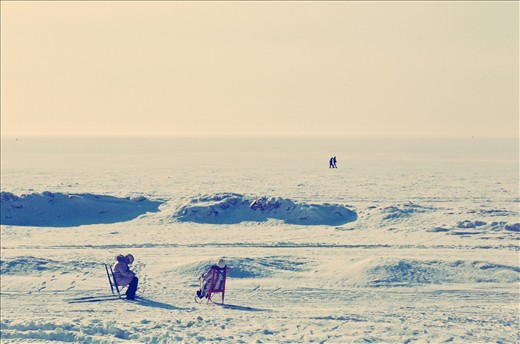 Two ladies taking the sun in the frozen beach of Saint Petersburg