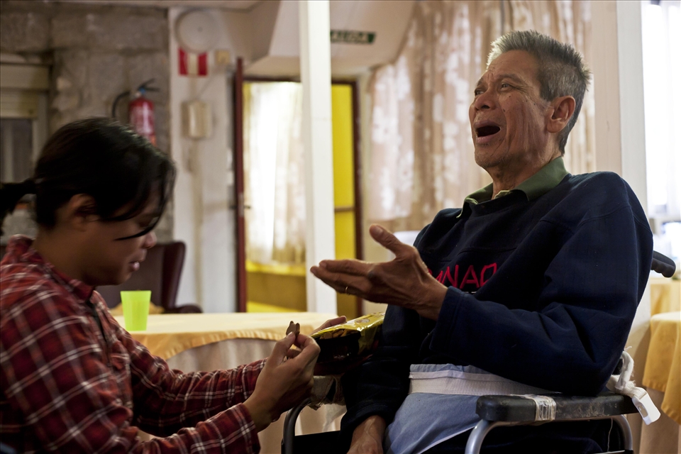 ‘The place I have visited’ is the residence for elder people where my father has lived for two months. It is not an exciting place, but it is close to my heart and I thought I should do something that touches me from inside.
A few months ago he suffered a severe stroke that affected his mobility, and above everything, the way he interacts with the world. Now he can neither speak nor understand us, and in fact I don’t think he can even recognise us. In this picture, my brother is pulling his wheelchair to get him closer, as my father is asking for some cookies, like a kid would do.