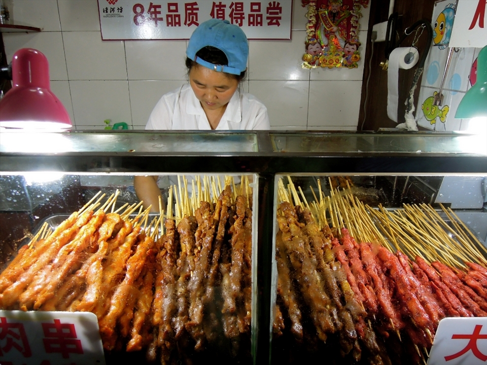 A street vender sells meat-on-a-stick in one of Hangzhou's most popular tourist areas before the bird flu epidemic hit and most people stopped eating chicken and other poultry related products. 