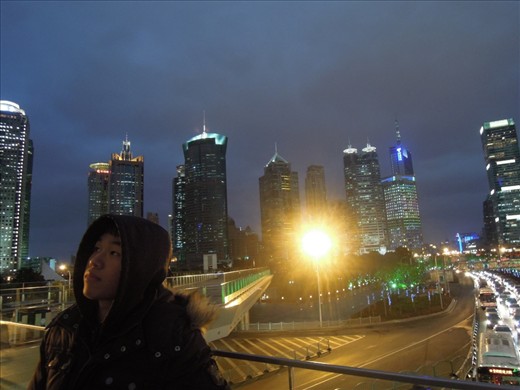 Angel Zhou Lin admires the Shanghai skyline on a cold night in February. Angel is an architecture graduate from Spain where his parents immigrated the year he was born. After little success finding a job in Spain, he is now back in his parent's homeland studying Mandarin Chinese. 