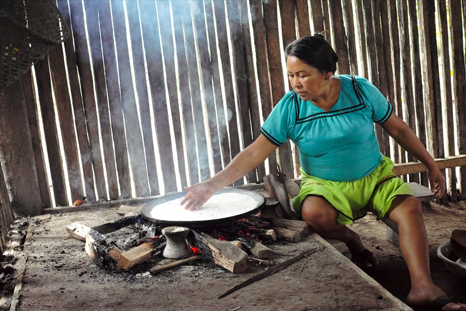 A woman is showing the process of making bread out of yuca.