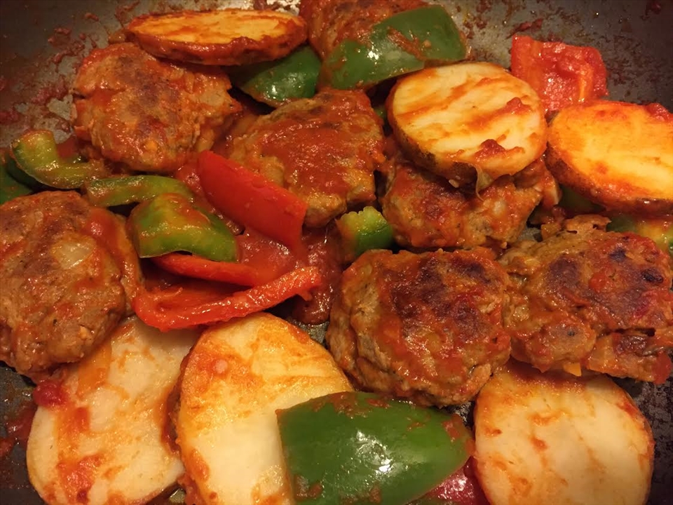 Almost Done! Mix tomato paste with hot water and spread over köfte.  Sprinkle with salt.  Add potatoes (optional), mixed peppers and cook on medium heat for 20-25 minutes.
